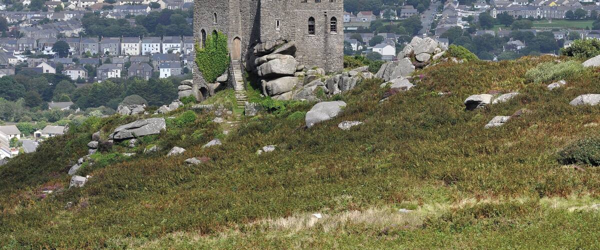 A historic stone castle on a hill overlooking a town.