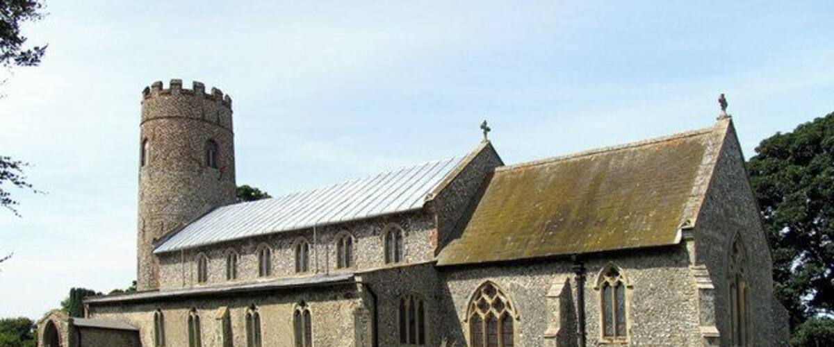 A historic stone church with a tower and arched windows.