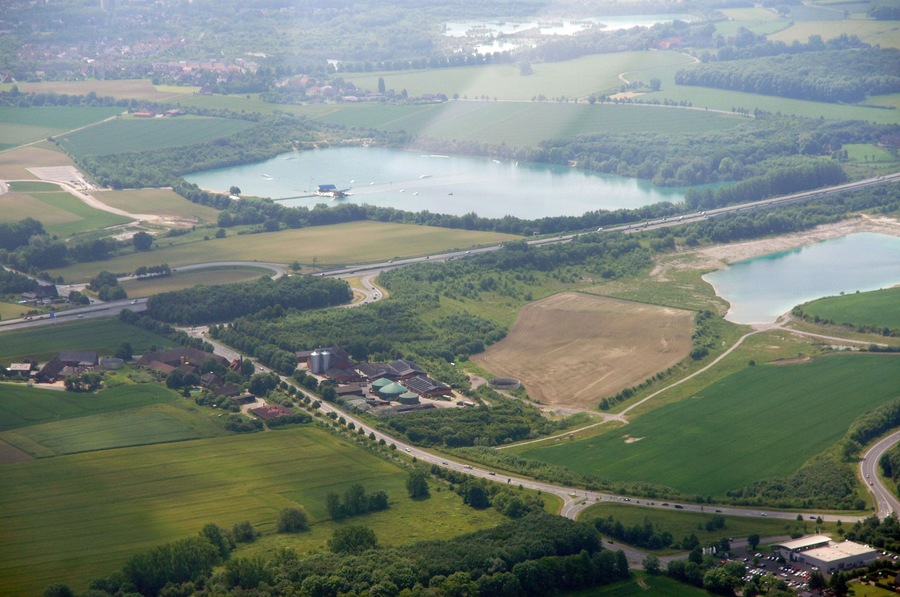 Vista aèria d'un paisatge rural amb diverses llacs, camps i alguns edificis.
