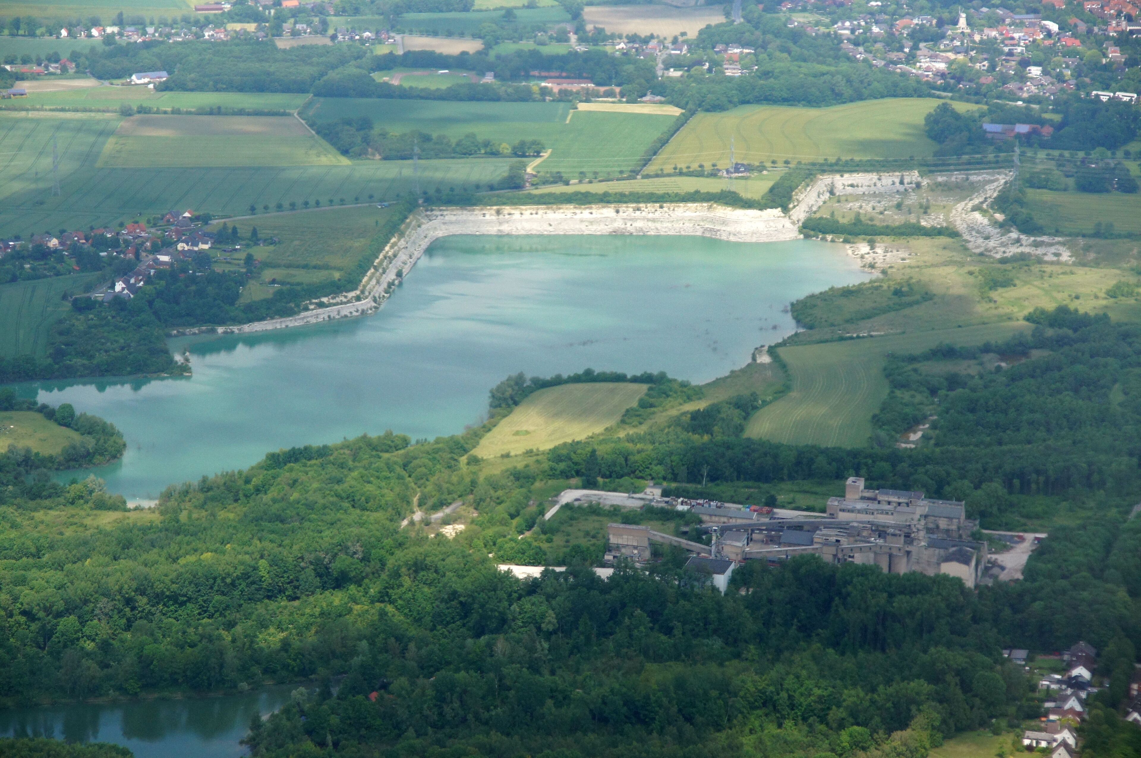 Zementwerk Anneliese III und Naturschutzgebiet Steinbruch Anneliese bei Ennigerloh im Kreis Warendorf, NRW. Das Bild entstand während des Münsterland-Fotoflugs am 1. Juni 2014. Hinweis: Die Aufnahme wurde aus dem Flugzeug durch eine Glasscheibe hindurch fotografiert.