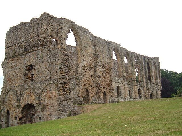 A large, historic stone structure with multiple arches and ruins.