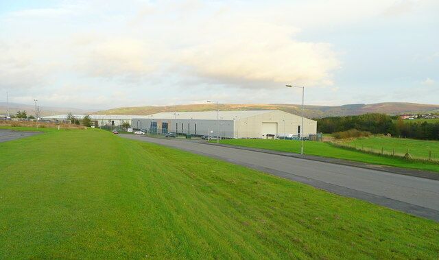 A large industrial building with a paved road in front.