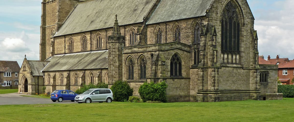 A large stone church with a prominent tower and arched windows.