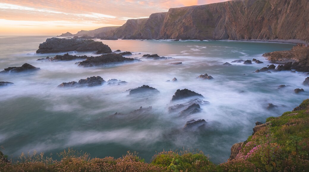 Dramatic seascape landscape of rock Atlantic coastline with colourful sunset or sunrise sky at Hartland Quay on the North Devon coast in England, UK.