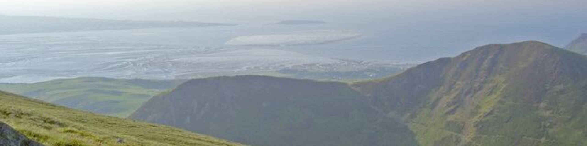 The hillside With a falling tide in the Menai Strait beyond Foel Dduarth and Foel-ganol.