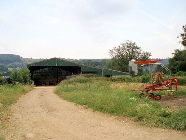 Barn. The barn is on the opposite side of the road to Lower silver street farm, and I believe the red 'contraption' on the right is a threshing machine of some sort.