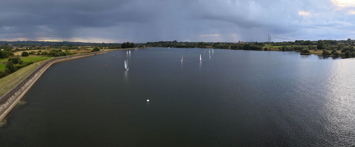 Aerial Panorama of Dinghy Sailing on Elton Reservoir Under Rain Clouds