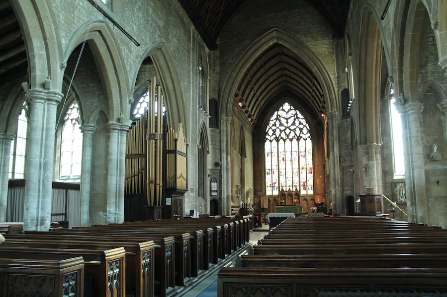 The church dates from circa 1300 onwards. It was restored in 1867 and 1887. It is one of the finest 14th century churches in England. Built between 1305 and 1333, it replaced an earlier church which was recorded in the Domesday book. The church was probably begun by Lora de Gant, Lady of the Manor of Heckington. Its greatest glories are due to the generosity of two men linked with King Edward II, Lord Henry de Beaumont and master Richard de Potesgrave. Beaumont's coat of arms once appeared in many of the stained-glass windows. Richard de Potesgrave (circa 1275 to 1349) was rector of Heckington in 1309 and was the Kings' chaplain. In 1321 he was given custody of Leeds Castle in Kent. The church consists of a west tower with spire, clerestoried nave, north and south aisles, transepts, chancel, south porch and north Chapel The three stage tower and spire is 185 feet high with three tiers of lucarnes. There are multiple gargoyles on gabled niches as well as on crocketted pinnacles. The south porch dates from the decorated period although suffered from vandalism to statues in niches. Over the entrance is a statue of Christ in Glory. Inside, there are four bay north and south nave arcades with octagonal piers. There was originally a Rood screen separating the nave and the chancel. The north aisle is probably the oldest part of the church and the north transept was formerly used as a Chantry Chapel, the piscina is still in position. The south transept, has its own sedilia, and in the south-west corner there is a burial slab with an engraved bust, possibly Potesgrave's father from the 14th century. The south transept was probably the "Chantry of Saint Nicolas" where rector Potesgrave's parents were prayed for. The chancel was built by Potesgrave whose tomb is recessed into the north wall with a damaged effigy. He died in 1349 aged about 75, possibly of the Black Death. When the tomb was opened in 1800 his communion chalice was found inside. The east window is 34 foot high and 16 feet wide with seven lights. On the north wall of the chancel is an Easter Sepulchre, complete with sleeping soldiers beneath crocketted gables. To either side are figures, and above is the risen Christ attended by censing Angels. The Sepulchre was also used as a permanent sacrament shrine, where consecrated bread and wine were kept. There is also a double piscina in the chancel and an elaborate triple sedilia with fine decorative carvings depicting Saint Margaret with her Dragon, the coronation of the Virgin Mary and Christ, Saint Catherine with her wheel, and other Angels. Pic by Jenny.