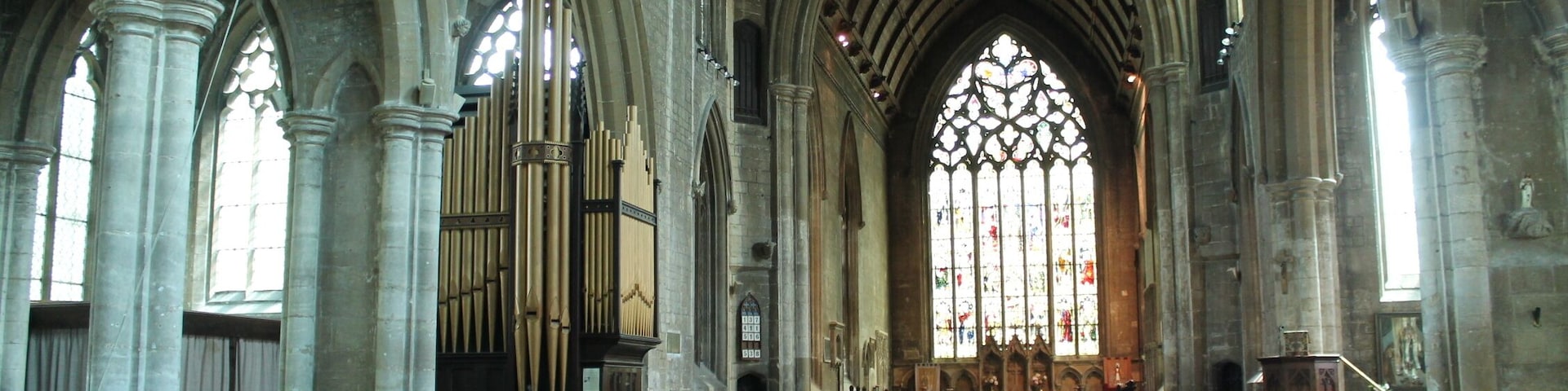 The church dates from circa 1300 onwards. It was restored in 1867 and 1887. It is one of the finest 14th century churches in England. Built between 1305 and 1333, it replaced an earlier church which was recorded in the Domesday book. The church was probably begun by Lora de Gant, Lady of the Manor of Heckington. Its greatest glories are due to the generosity of two men linked with King Edward II, Lord Henry de Beaumont and master Richard de Potesgrave. Beaumont's coat of arms once appeared in many of the stained-glass windows. Richard de Potesgrave (circa 1275 to 1349) was rector of Heckington in 1309 and was the Kings' chaplain. In 1321 he was given custody of Leeds Castle in Kent. The church consists of a west tower with spire, clerestoried nave, north and south aisles, transepts, chancel, south porch and north Chapel The three stage tower and spire is 185 feet high with three tiers of lucarnes. There are multiple gargoyles on gabled niches as well as on crocketted pinnacles. The south porch dates from the decorated period although suffered from vandalism to statues in niches. Over the entrance is a statue of Christ in Glory. Inside, there are four bay north and south nave arcades with octagonal piers. There was originally a Rood screen separating the nave and the chancel. The north aisle is probably the oldest part of the church and the north transept was formerly used as a Chantry Chapel, the piscina is still in position. The south transept, has its own sedilia, and in the south-west corner there is a burial slab with an engraved bust, possibly Potesgrave's father from the 14th century. The south transept was probably the "Chantry of Saint Nicolas" where rector Potesgrave's parents were prayed for. The chancel was built by Potesgrave whose tomb is recessed into the north wall with a damaged effigy. He died in 1349 aged about 75, possibly of the Black Death. When the tomb was opened in 1800 his communion chalice was found inside. The east window is 34 foot high and 16 feet wide with seven lights. On the north wall of the chancel is an Easter Sepulchre, complete with sleeping soldiers beneath crocketted gables. To either side are figures, and above is the risen Christ attended by censing Angels. The Sepulchre was also used as a permanent sacrament shrine, where consecrated bread and wine were kept. There is also a double piscina in the chancel and an elaborate triple sedilia with fine decorative carvings depicting Saint Margaret with her Dragon, the coronation of the Virgin Mary and Christ, Saint Catherine with her wheel, and other Angels. Pic by Jenny.