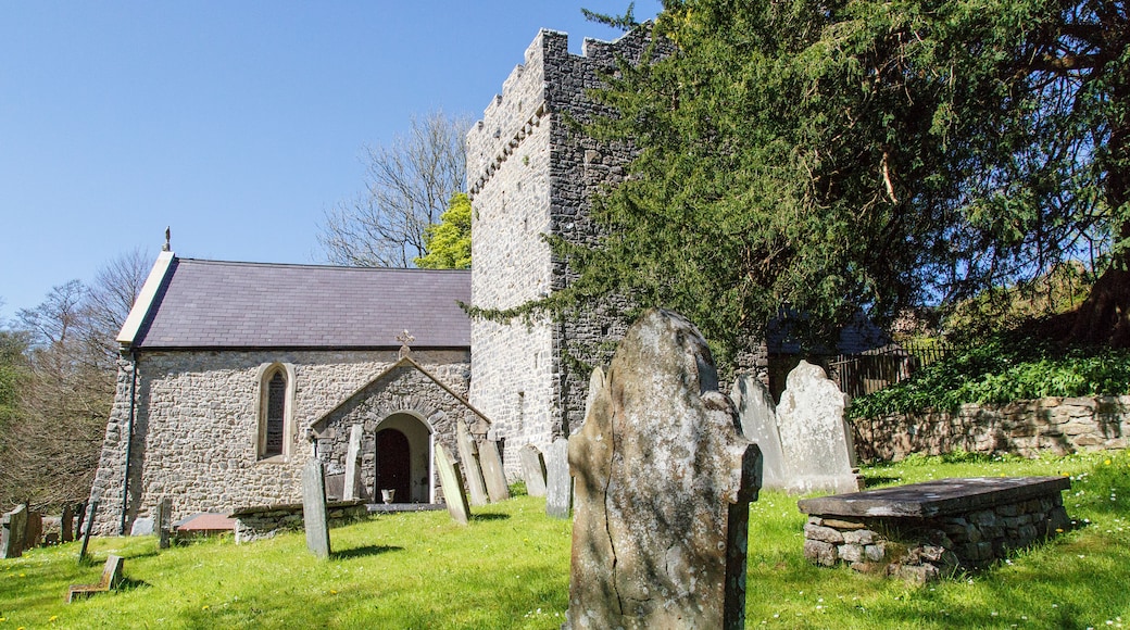 A stone church with a bell tower and a graveyard with headstones.
