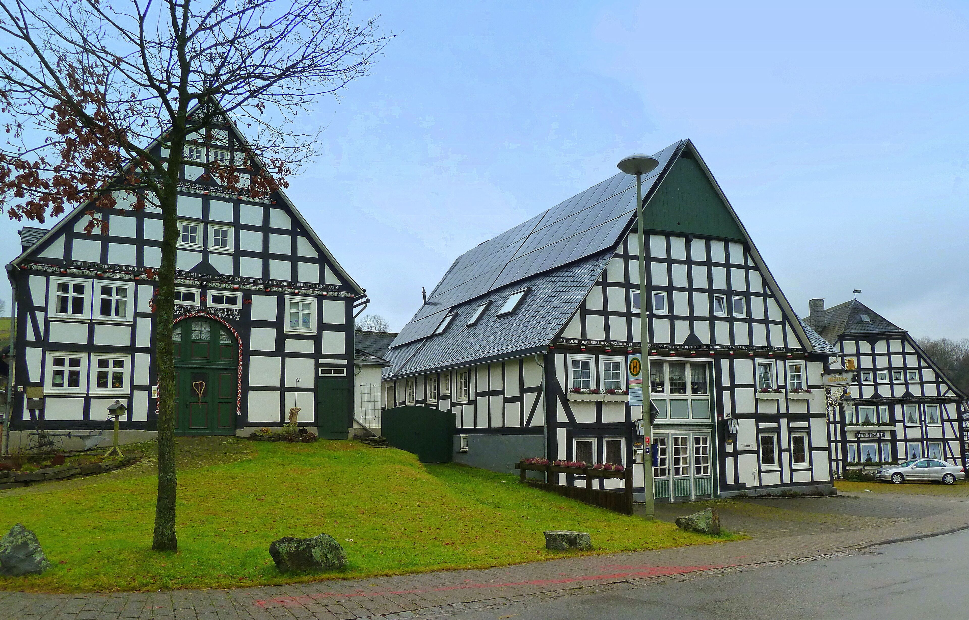 A traditional half-timbered house with a sloped roof and a green door.