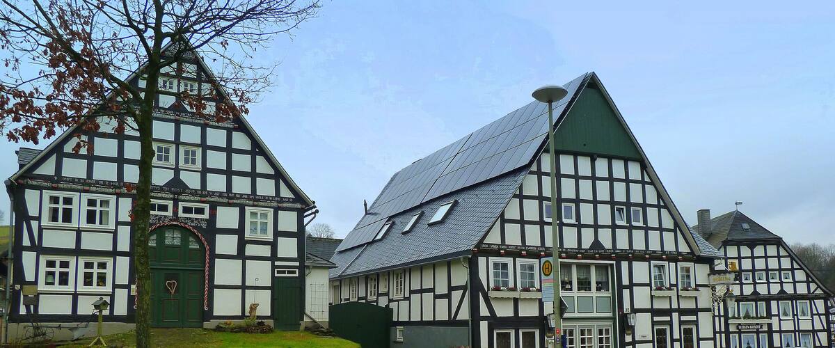 A traditional half-timbered house with a sloped roof and a green door.