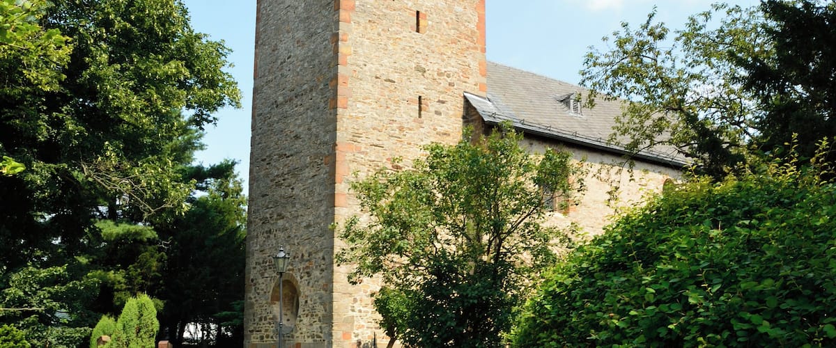 Eine steinerne Kirche mit einem Turm und einem Weg dorthin.