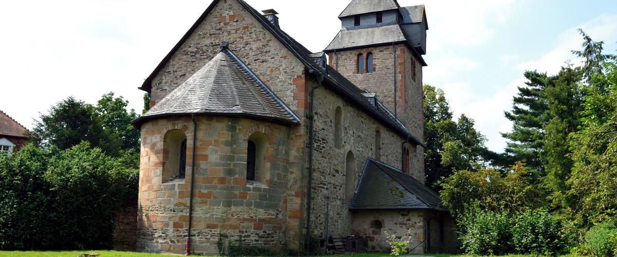 A historic stone church with a bell tower and a small tower.
