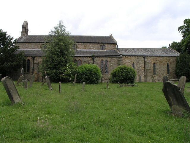 A church with a graveyard in front.