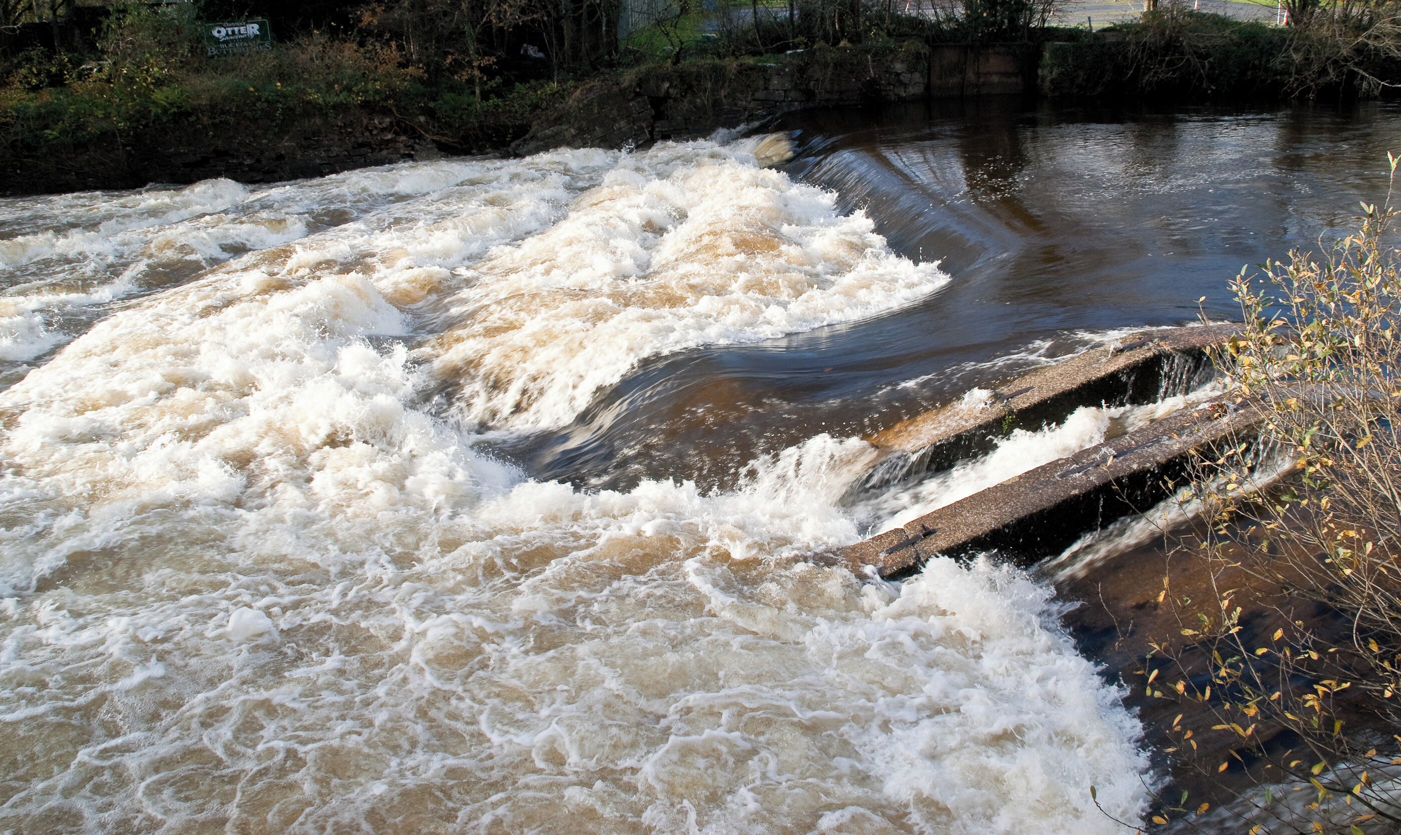 A turbulent river with a concrete weir.