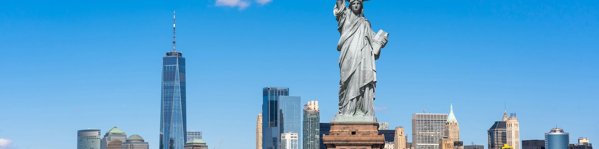 Die Freiheitsstatue in New York City mit der Skyline im Hintergrund.