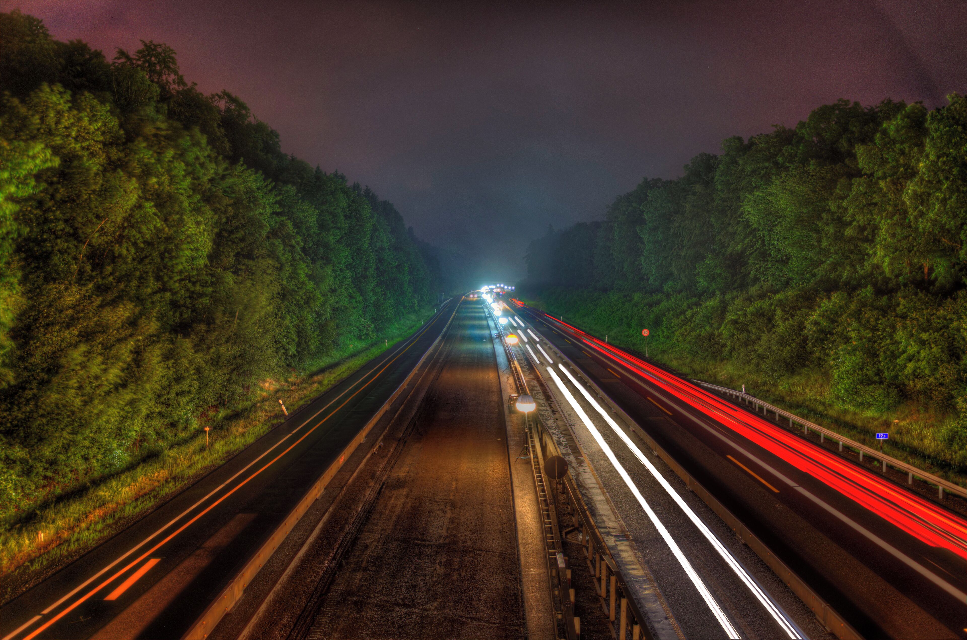 A highway at night with light trails from vehicles.