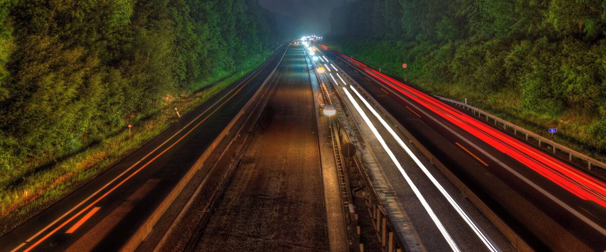 A highway at night with light trails from vehicles.