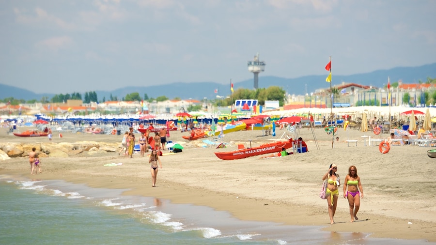 Ein belebter Strand mit Menschen, Sonnenschirmen und Booten.