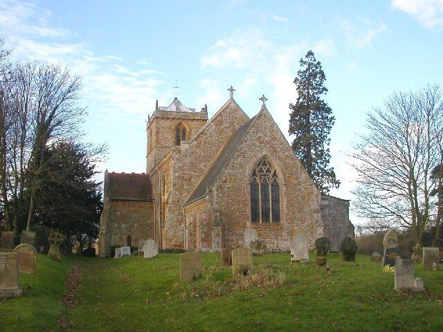 A historic church with a tall tower and pointed arch windows, surrounded by a cemetery.