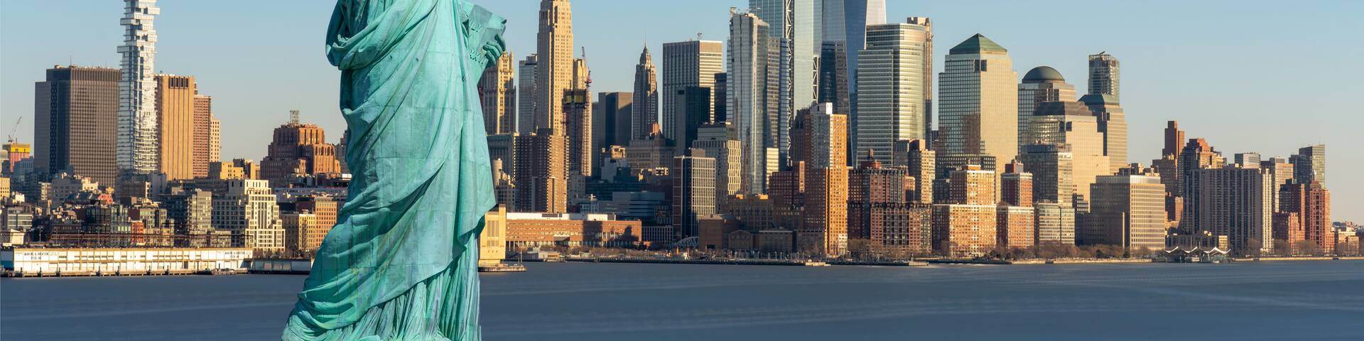 The Statue of Liberty in New York City with the skyline in the background.