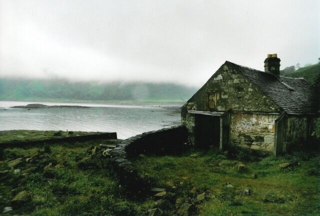 A stone house by a misty coastal area.