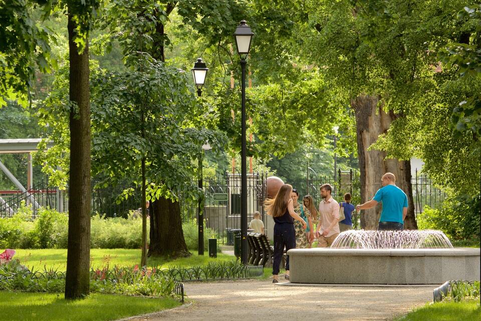 A park with trees, a fountain, and a playground.