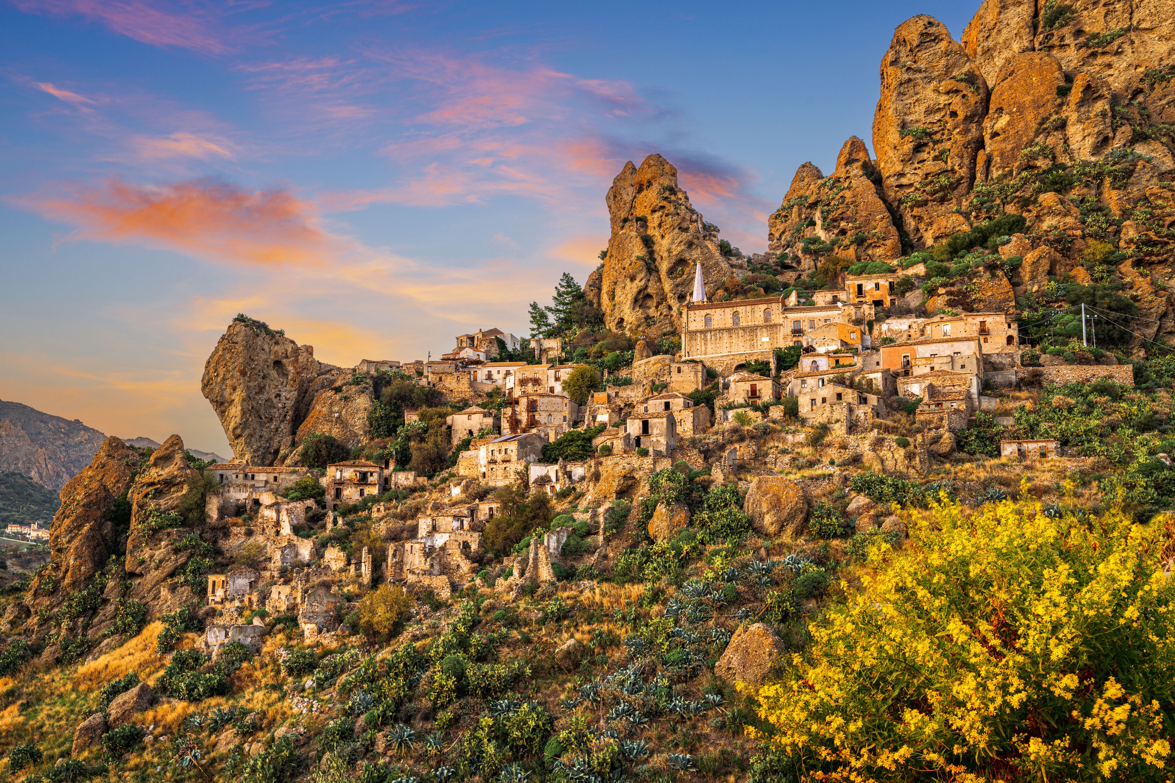 Un pueblo montañoso con antiguas construcciones de piedra encaramado a escarpados riscos.