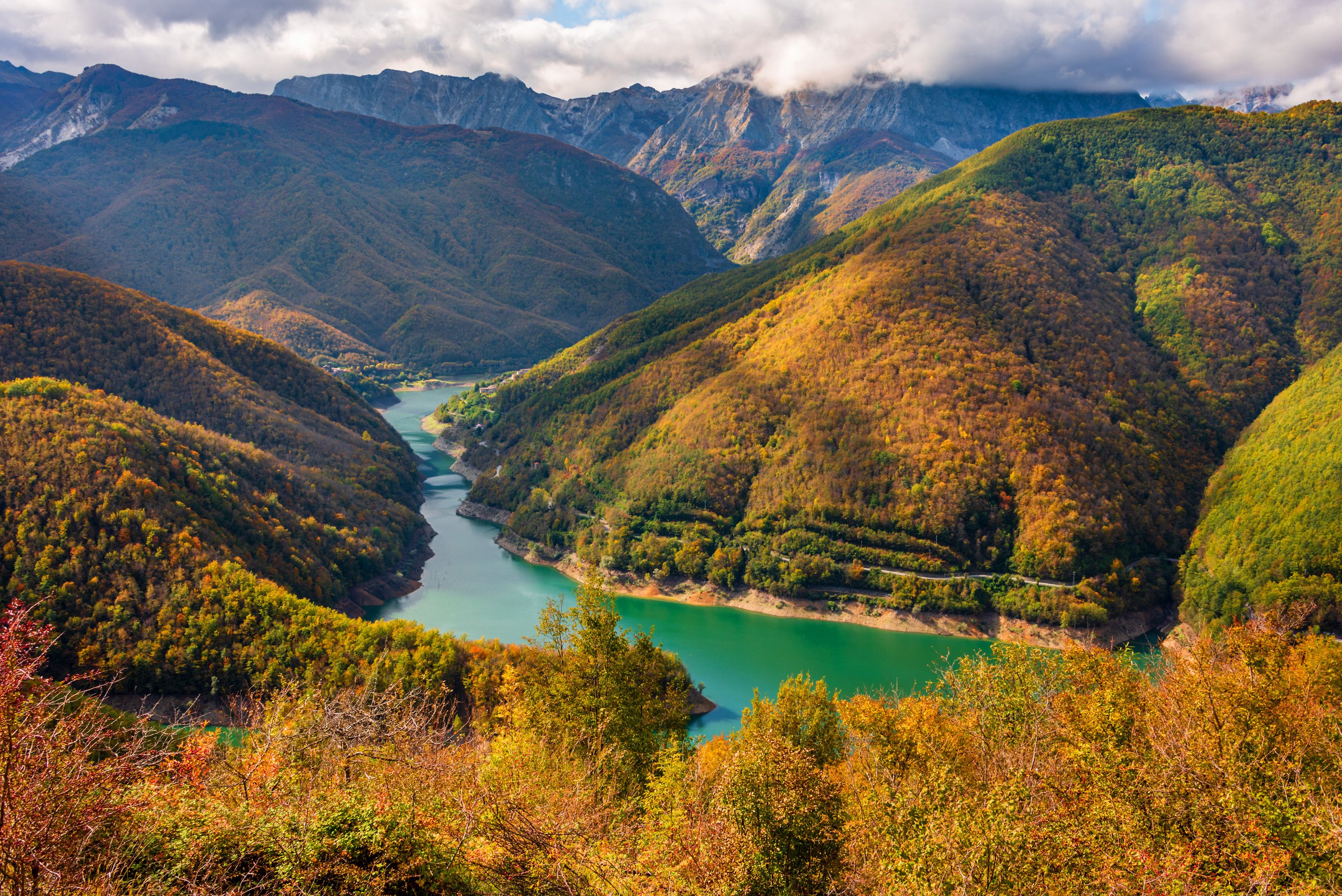 Een bergachtig landschap met een rivier die door een vallei kronkelt.