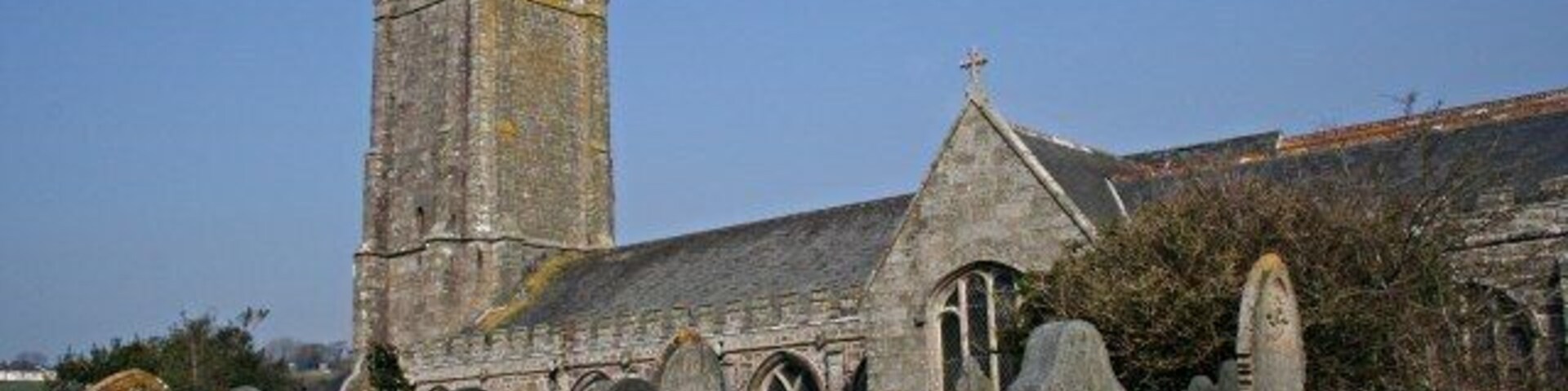 Una iglesia con una torre alta y un cementerio con lápidas.