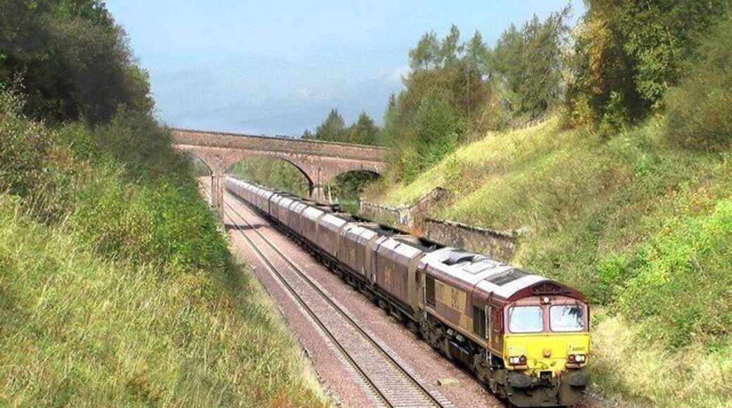 Site of Crosby Garrett station This south bound coal train is passing the site of Crosby Garrett station. Closed in 1956, the platforms were set into the cutting needing hefty retaining walls. The station house which still exists as a private dwelling is hidden from view behind the trees on the right of the overbridge.
