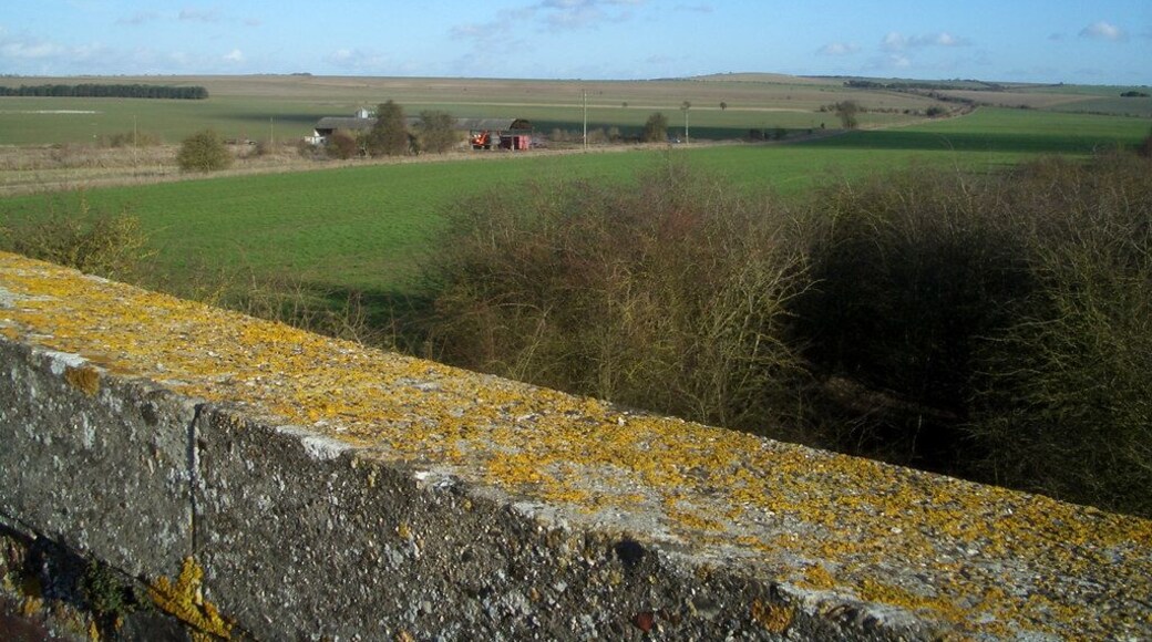 View from a Bridge Looking from the parapet of an old railway bridge over the open farmland on Blewbury Down. Just to the south of the steep scarp where the chalk downs give way to the flat Thames valley, this area is surprisingly level compared with the usual undulating downland topography. The buildings middle distance were once an extensive pig unit, but were being demolished as this photo was taken.