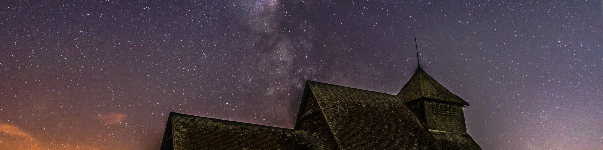 Un granero bajo un cielo lleno de estrellas.