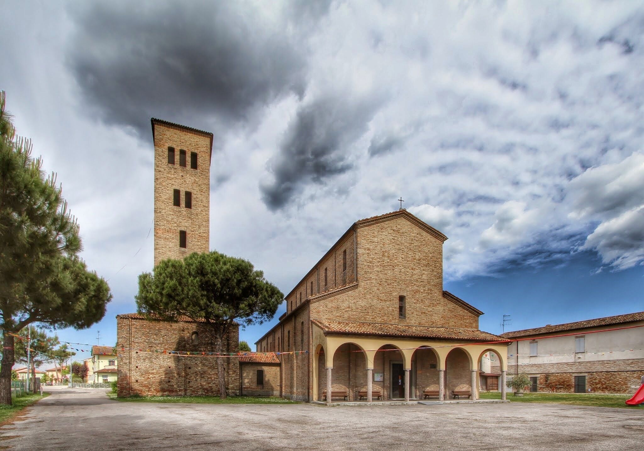 A historic building with a tall tower and arched portico.