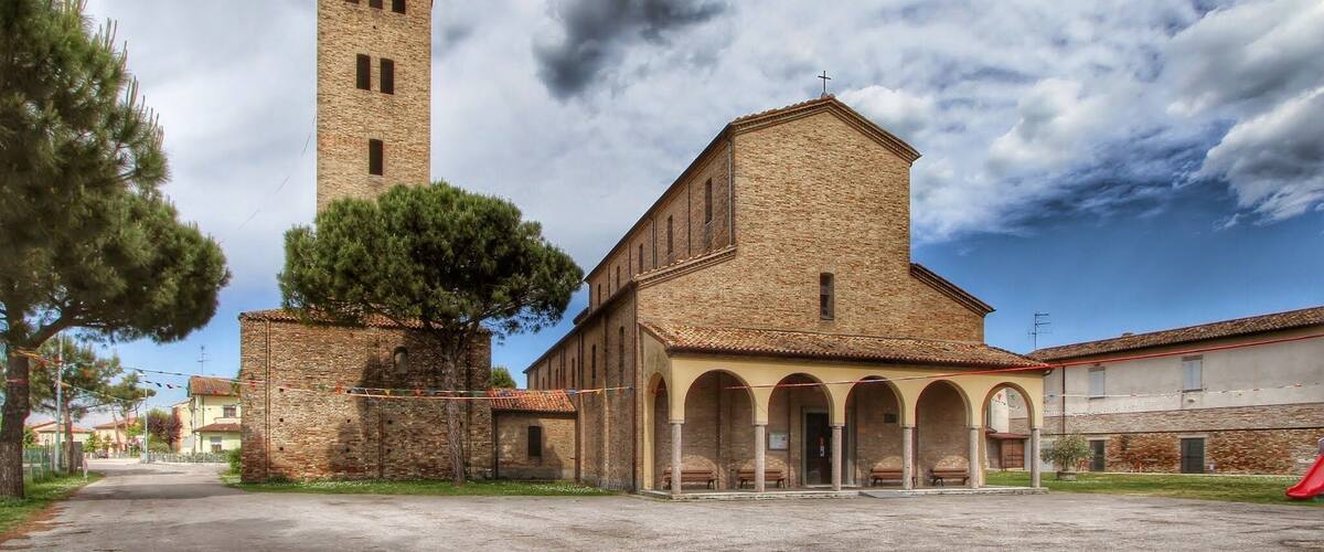 A historic building with a tall tower and arched portico.