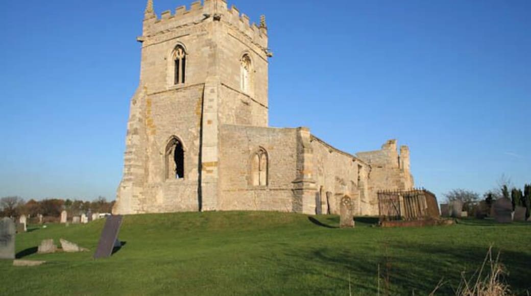 Tower and south aisle, St Mary's Church. Colston Bassett. This clearly shows the stages of the building of the tower. The early 13th century part is in rough blocks of blue lias limestone in thin courses. The later 15th century addition uses a facing of more substantial blocks of white limestone. The large grave on the right is that of Andrew Basilico who died in 1824 aged 79 years. His wife, Sophia Charlotte is also buried here. She died in 1850 aged 67. See 613460 for a brief history of the church.