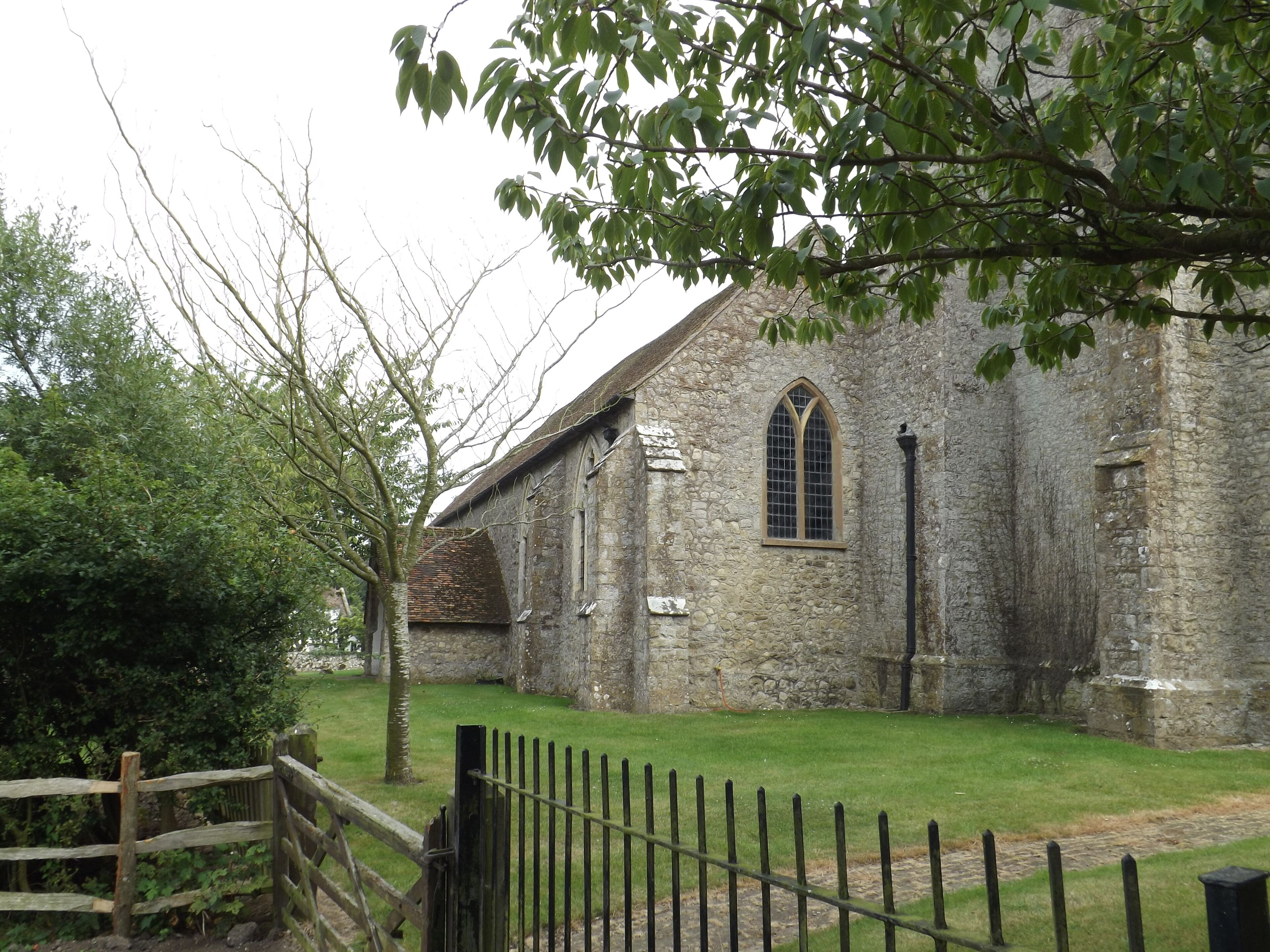 A stone church with a wooden fence in front.