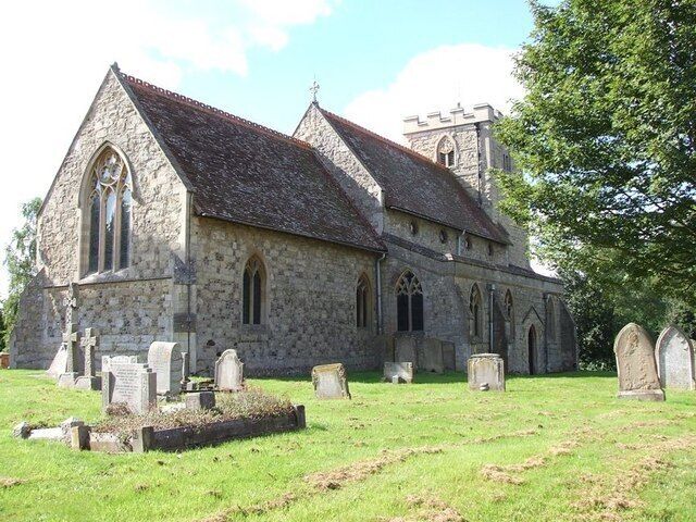 A historic stone church with a steeply pitched roof, arched windows, and a bell tower.