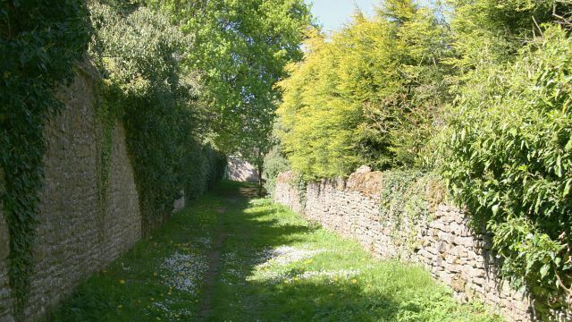 Footpath. The footpath links 421643 (ahead) with 426766 (behind the viewpoint). The high wall on the left is a boundary with Brompton Hall School. For a photograph taken from the same viewpoint but looking in the opposite direction (southerly), click here 426789. For a more northerly (ahead) photograph of the footpath, click here 421647.