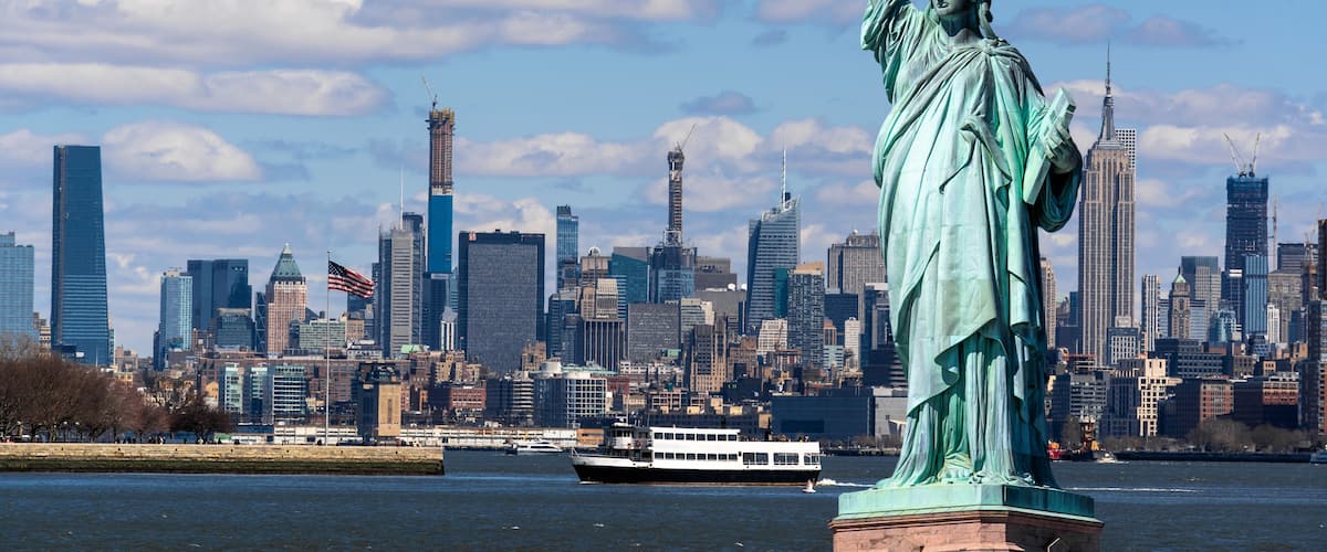 La statue de la Liberté à New York, avec la silhouette de Manhattan en arrière-plan.