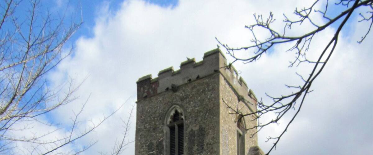 A stone church with a tall tower and arched windows.