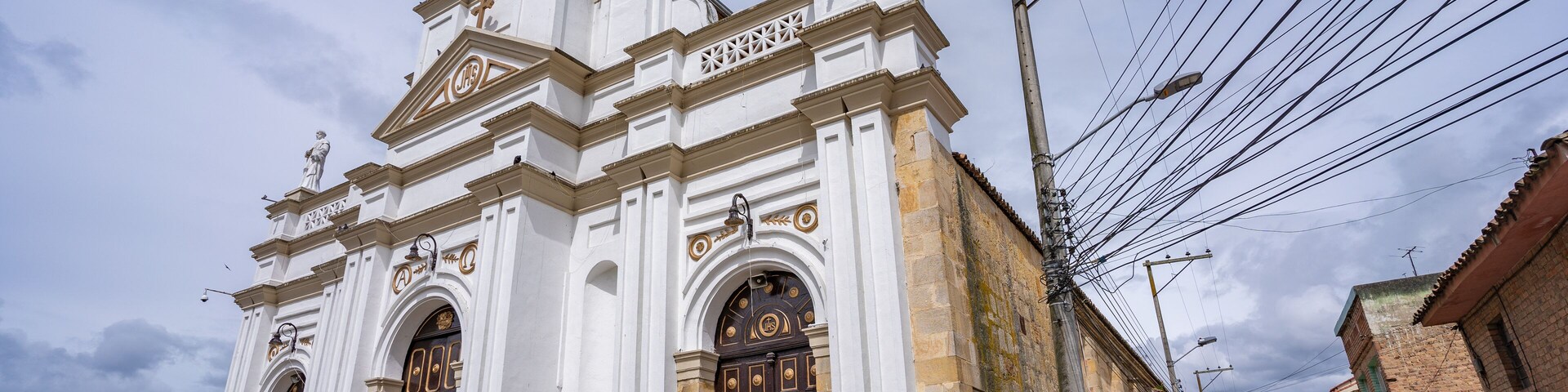 Una iglesia histórica con arquitectura ornamentada, una torre de campanas y una bicicleta estacionada adelante.