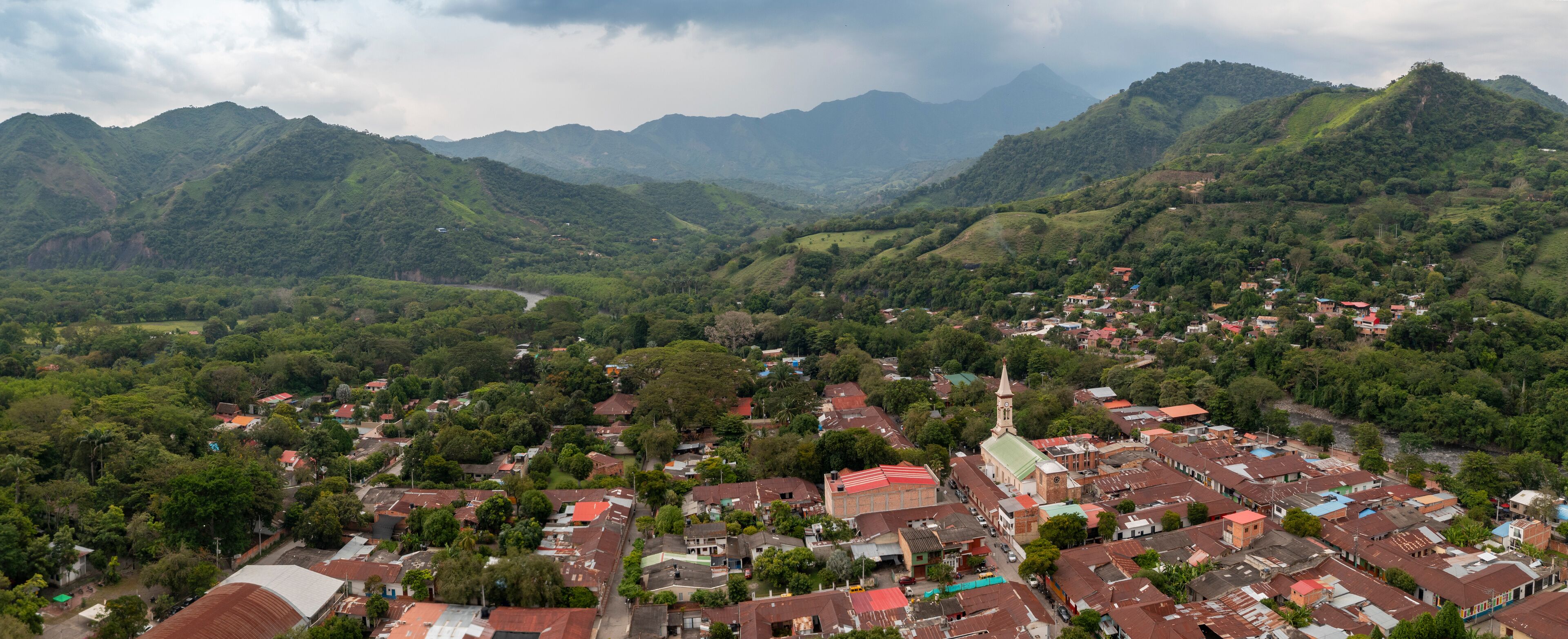 A town nestled in a valley surrounded by lush green mountains.