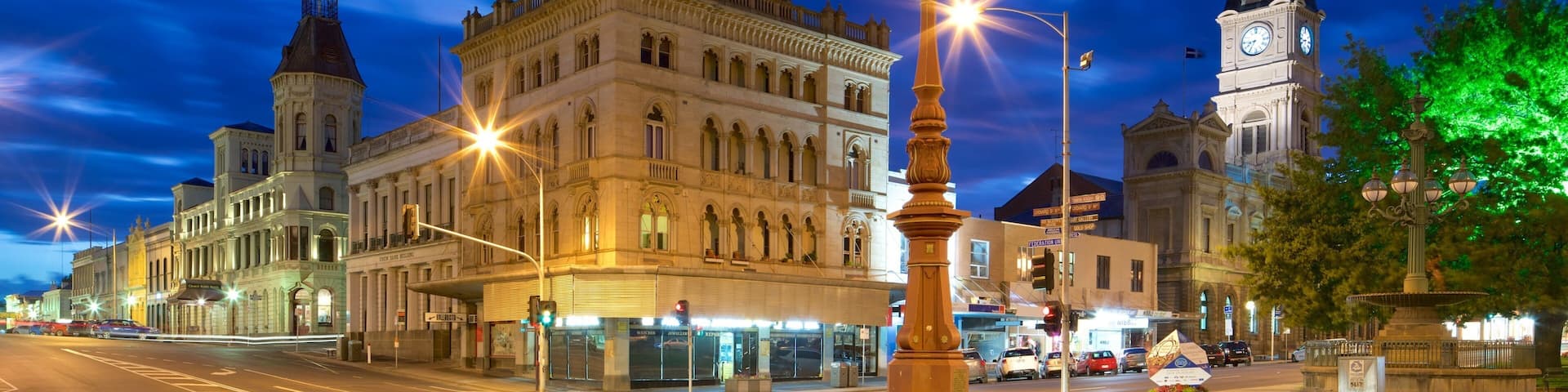 A historic building with a clock tower and ornate architecture at twilight.
