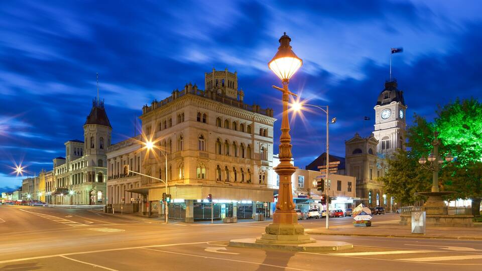A historic building with a clock tower and ornate architecture at twilight.