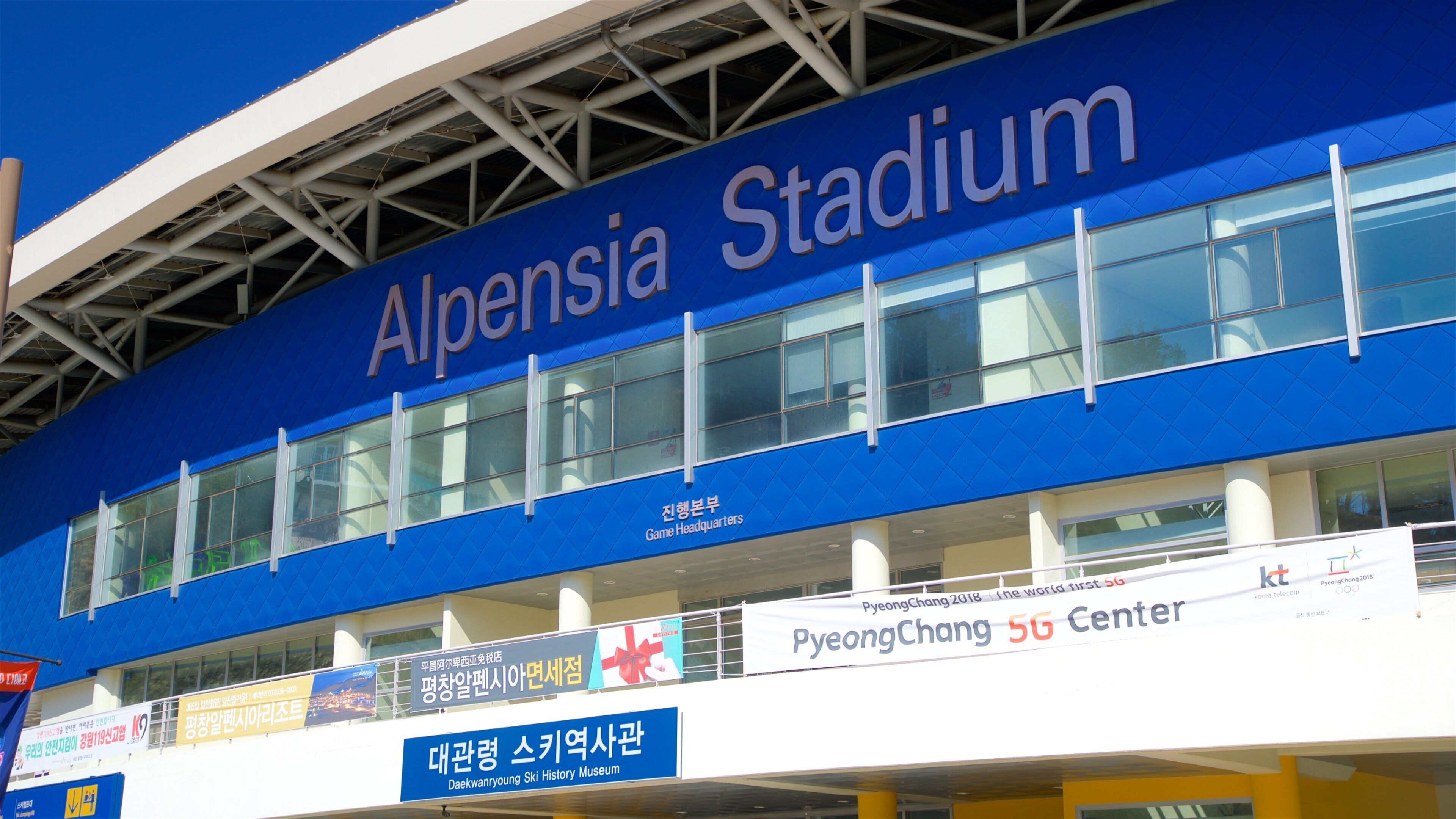 The exterior of Alpensia Stadium with signage for the PyeongChang 2018 Winter Olympics and the Daekwanryong Ski History Museum.