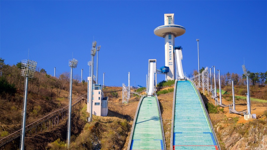 A ski lift with a chairlift and a gondola lift, surrounded by a mountainous landscape.