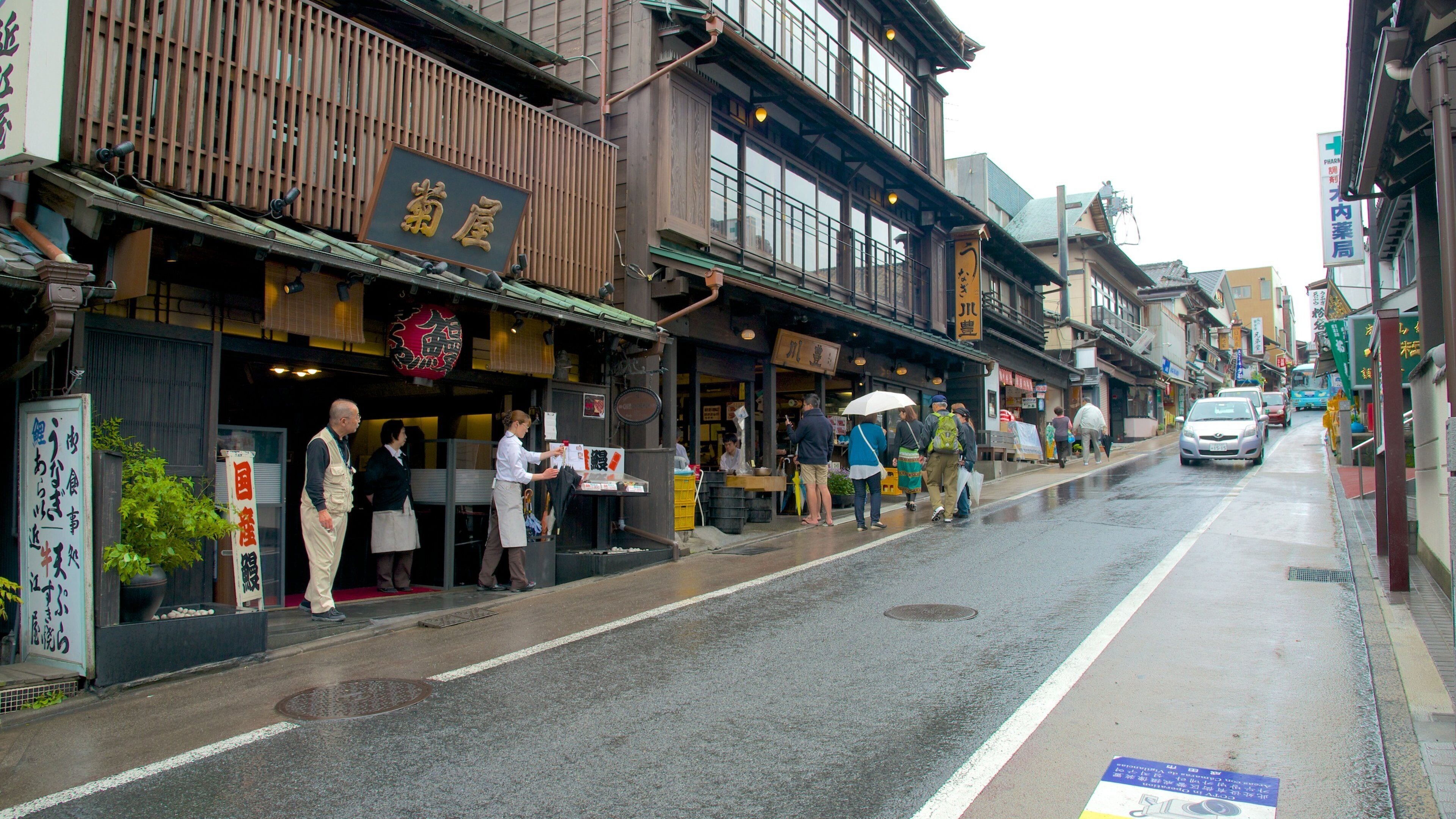 A street in a traditional Japanese town with wooden buildings and signs in Japanese.