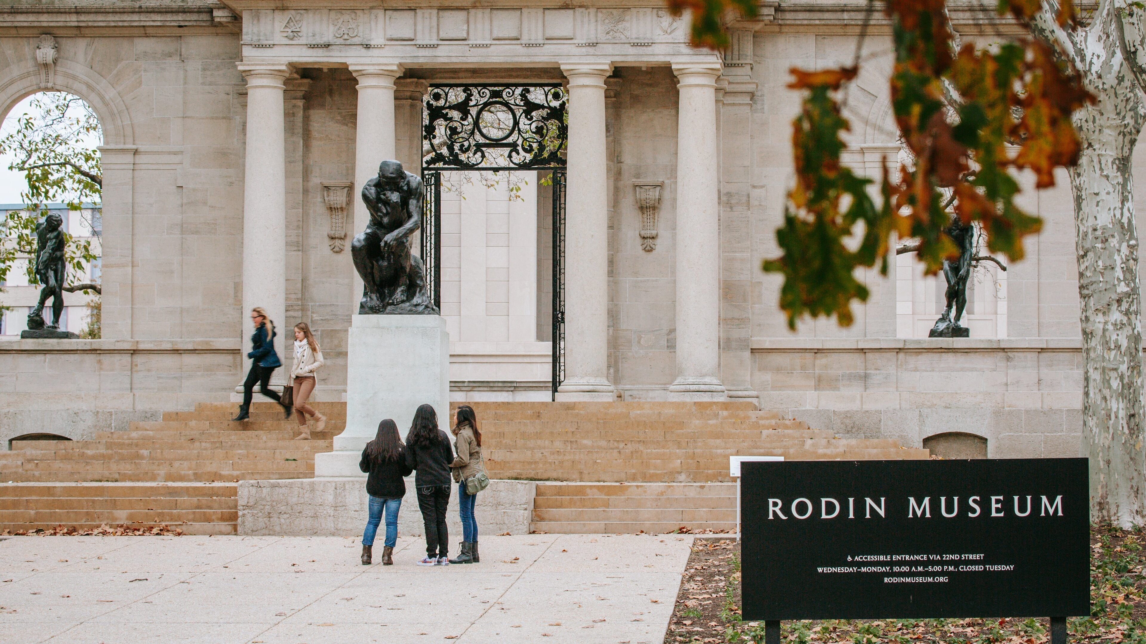 Benjamin Franklin Parkway showing signage and a statue or sculpture as well as a small group of people